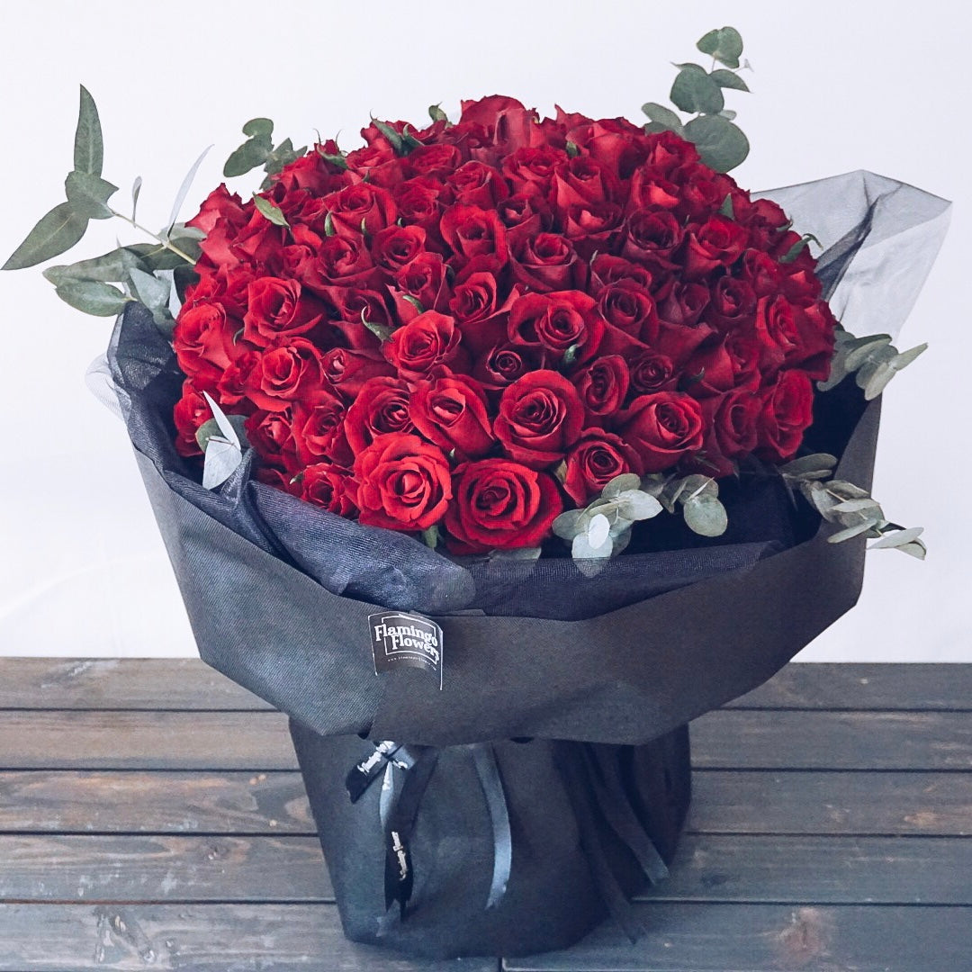 100 red rose bouquet in flamingo flowers style in black classy wrapping